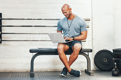 Buy stock photo Shot of a muscular young man using a laptop in a gym