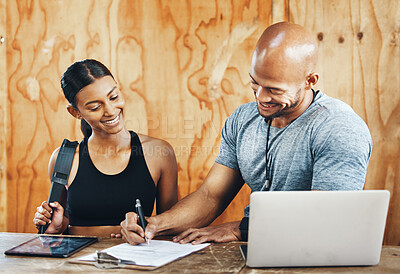 Buy stock photo Shot of a young man filling out paperwork while assisting a client in a gym