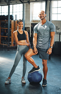 Buy stock photo Portrait of a sporty young man and woman standing together in a gym