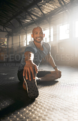 Buy stock photo Shot of a young man stretching his legs before a workout