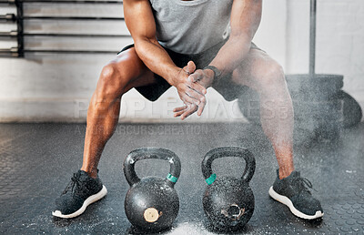 Buy stock photo Shot of a man dusting his hands with chalk before using kettlebells