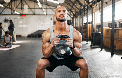 Buy stock photo Shot of a young man completing squats with a kettlebell