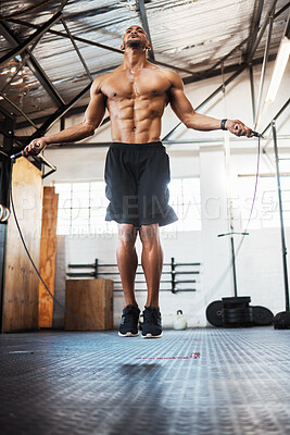 Buy stock photo Shot of a young man using a skipping rope during a workout