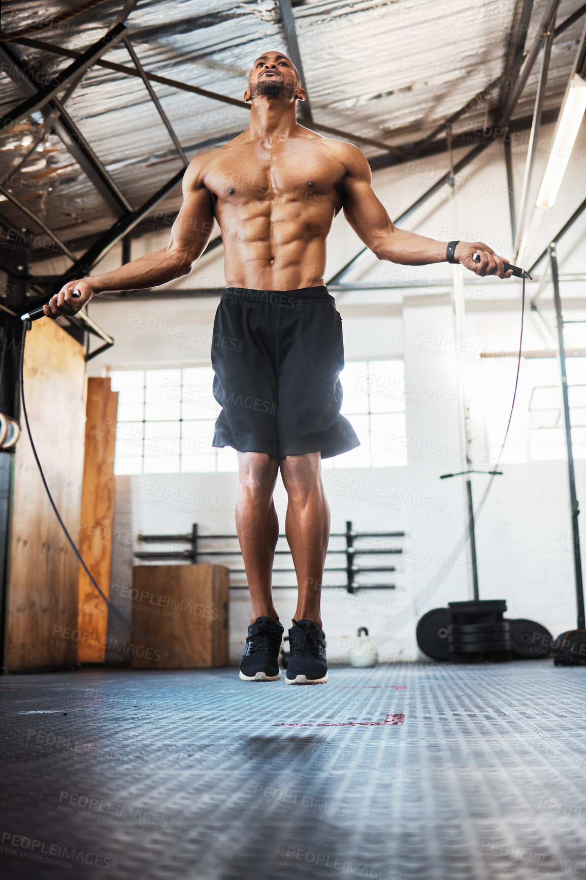 Buy stock photo Man, workout and jumping with skipping rope at gym for cardio exercise, weight loss or training. Active, muscular or male person with strength in air for fitness, endurance or stamina at health club