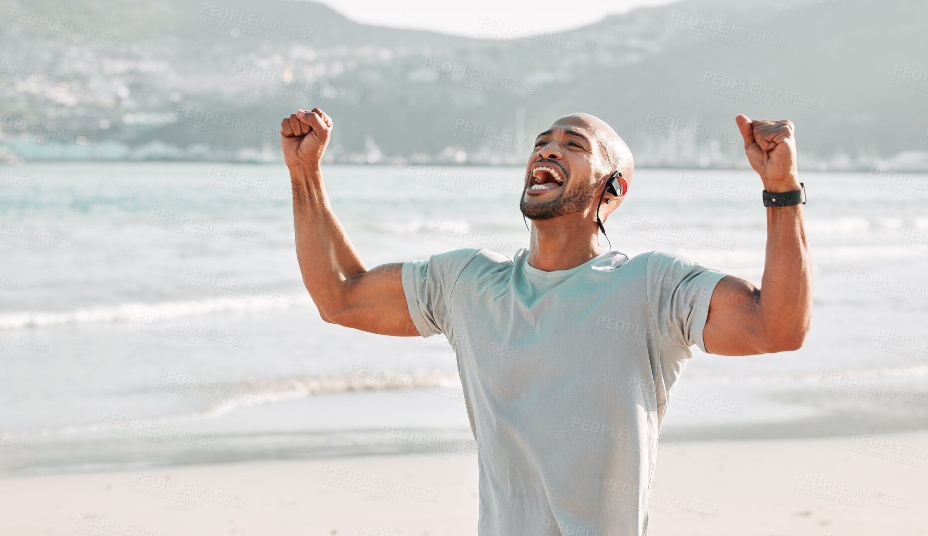 Buy stock photo Beach, celebration and fitness with African man, achievement and workout goals outdoor. Excited, fist and scream with happy athlete by sea with motivation, wellness and sport earphones for music