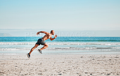 Buy stock photo Shot of a young man sprinting on the beach