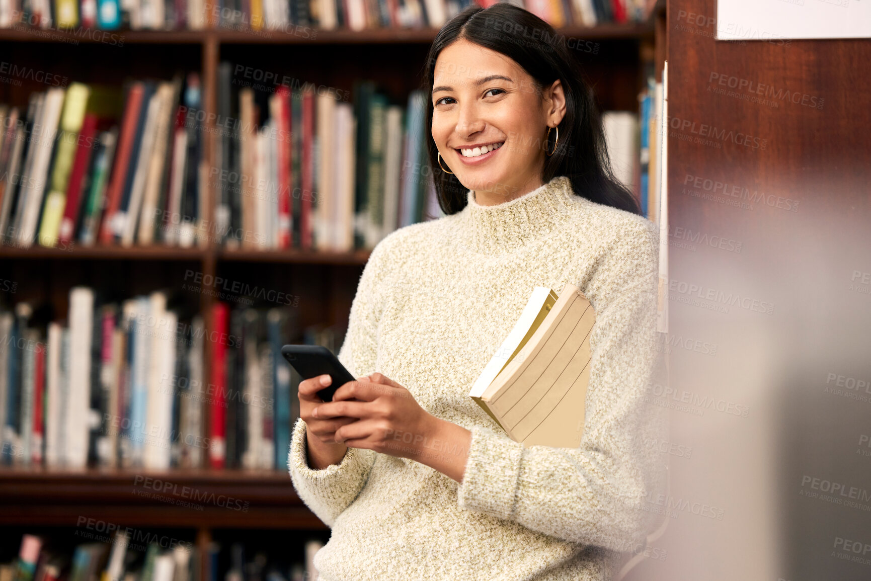 Buy stock photo Portrait, girl and student in library, smartphone and typing for research, education and relaxing with smile. Face, person and woman with cellphone, books and mobile user with contact or social media