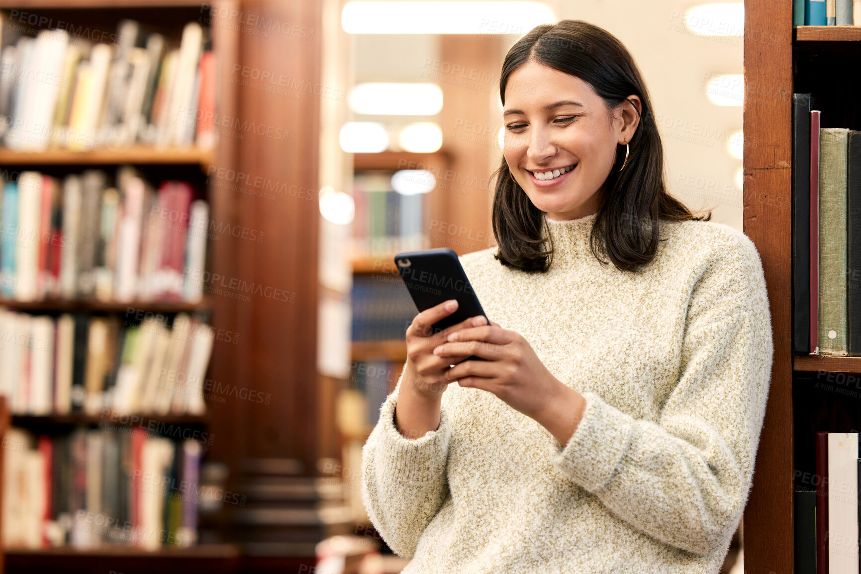 Buy stock photo College, library and smile of girl with phone for campus research, literature website or networking. Scholarship, student and person with smartphone for education, email or media update in London