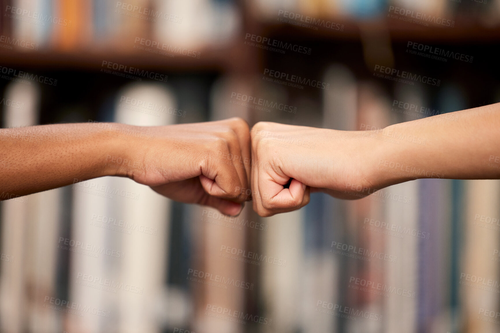 Buy stock photo College, friends and hands with fist bump in library for partnership, support and help in education. People, teamwork and campus at university with emoji for motivation, trust and achievement in exam