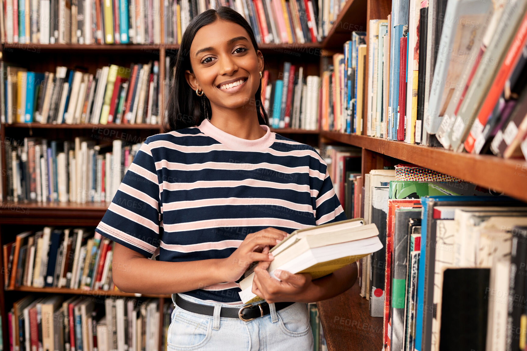 Buy stock photo College, library and portrait of girl by bookshelf with smile for literature research, education and study. Student, school and learning with book at campus for scholarship, knowledge and information