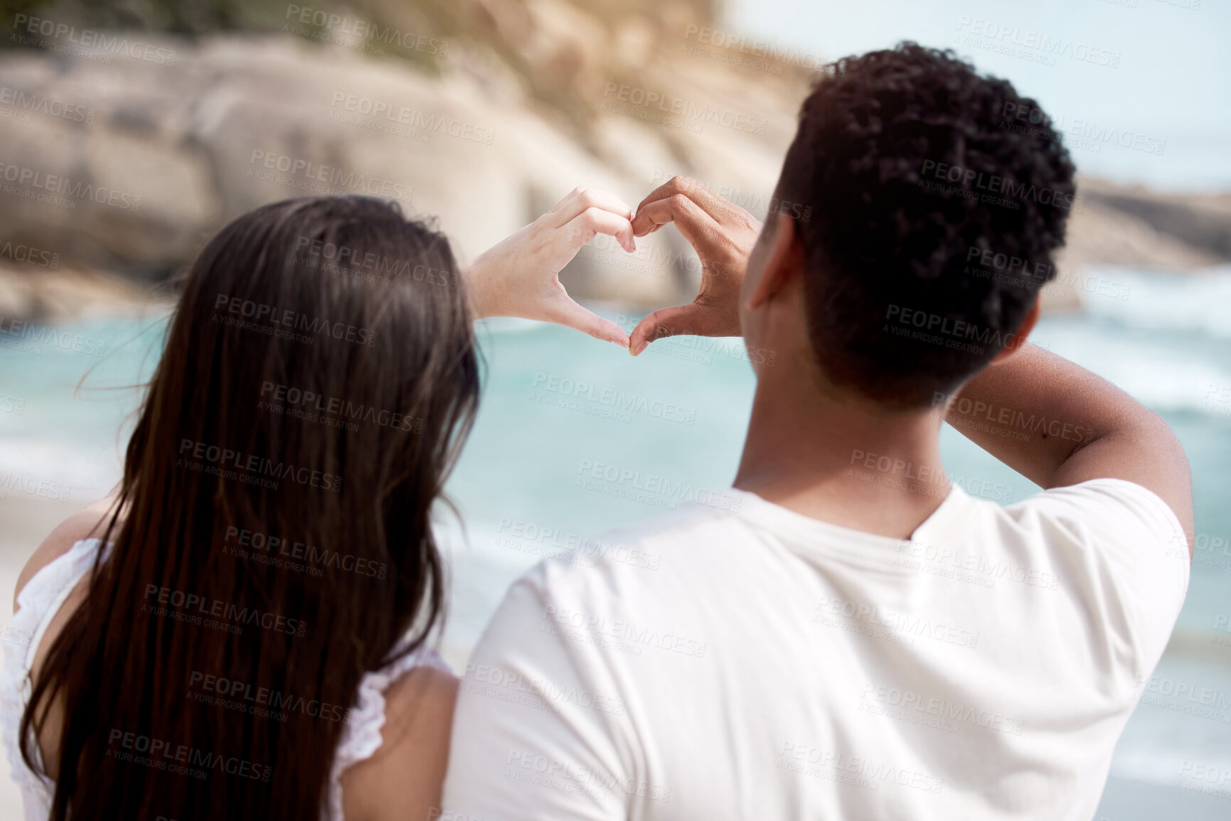 Buy stock photo Couple, beach and love with heart hands for valentines day, support or care together in nature. Rear view of man and woman with emoji for review, feedback or outdoor romance by sea or ocean coast