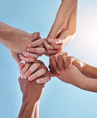 Buy stock photo People, team and holding hands together below for unity, collaboration or synergy on a blue sky background. Closeup or low angle of group or community in solidarity for care, support or mission