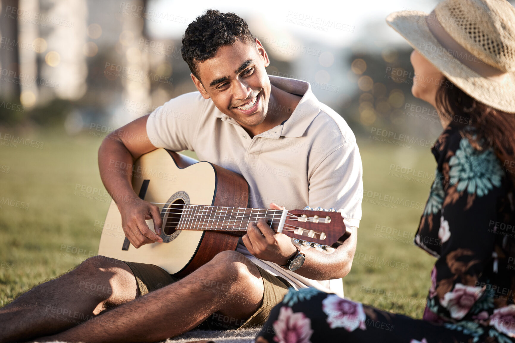 Buy stock photo Date, picnic and man with guitar for romance, love and anniversary in Puerto Rico. Couple, happy and music in outing on grass for summer, relax or happiness together at sunset with instrument in park