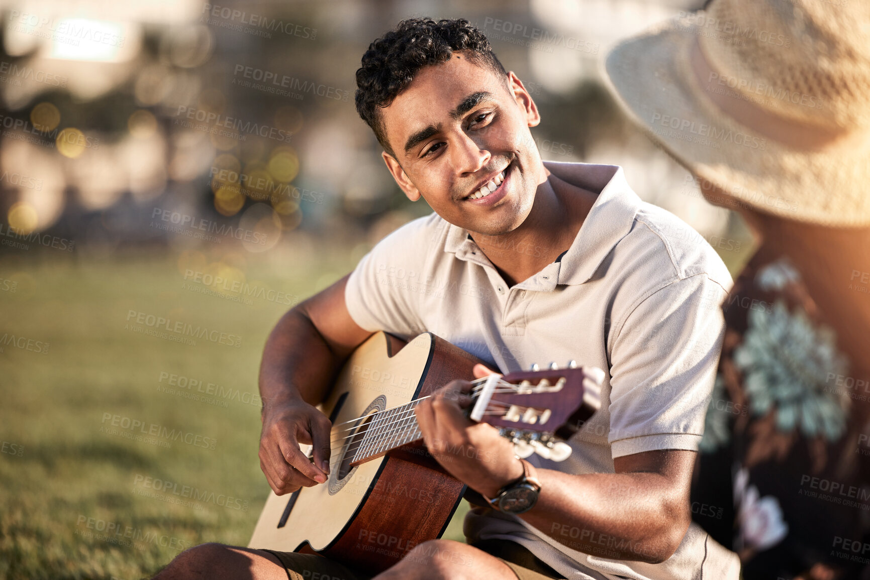 Buy stock photo Picnic, date and man with instrument for romance, love and anniversary in Puerto Rico. Couple, happy and music in outing on grass for summer, relax or happiness together at sunset with guitar in park