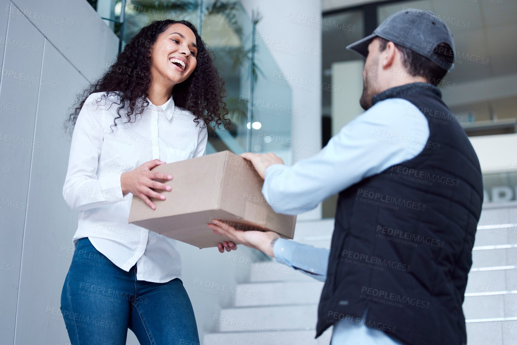 Buy stock photo Shot of a young woman receiving her delivery from the courier