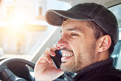 Buy stock photo Shot of a young delivery man talking on a cellphone while sitting in a van