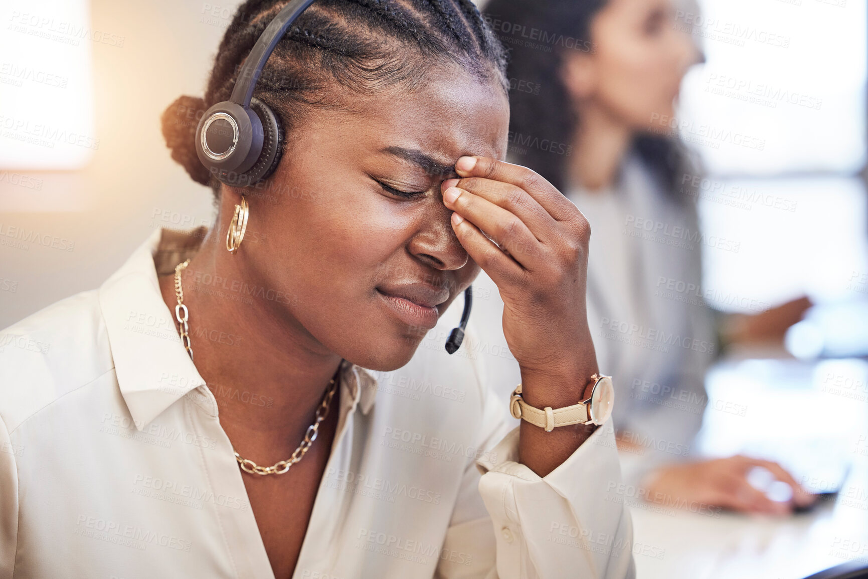 Buy stock photo Shot of a young businesswoman looking stressed at her call center job