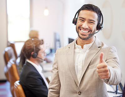 Buy stock photo Shot of a young businessman giving the thumbs up at his call center job