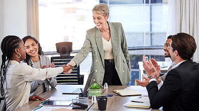 Buy stock photo Shot of a mature businesswoman standing and shaking hands with her colleagues during a meeting in the office