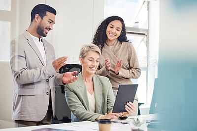 Buy stock photo Shot of a diverse group of businesspeople celebrating a success while using a digital tablet in the office