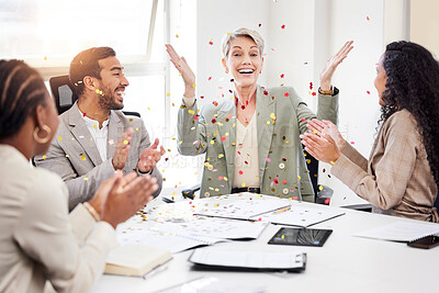 Buy stock photo Shot of a mature businesswoman sitting with her colleagues and throwing confetti to celebrate a success during a meeting
