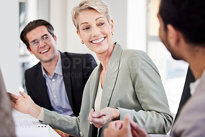 Buy stock photo Shot of a mature businesswoman sitting with her colleagues and leading a meeting in the office