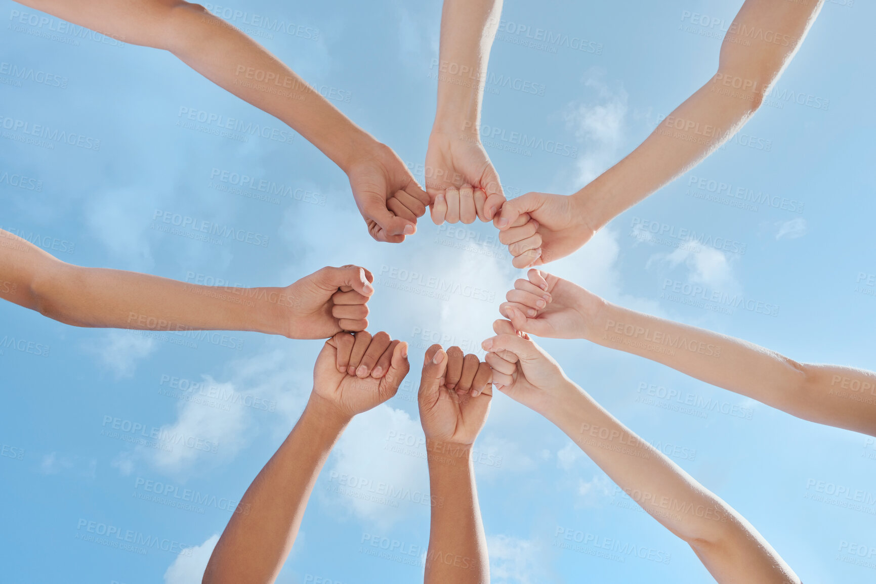 Buy stock photo People, hands and fist bump with circle below for teamwork, unity or community together with blue sky. Low angle of group touching in huddle for union, solidarity or collaboration in outdoor nature