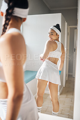 Buy stock photo Shot of an attractive young woman checking herself in the mirror in the locker room at a tennis arena