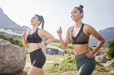 Buy stock photo Shot of two fit young women going for a run in a park