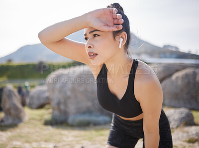 Buy stock photo Shot of a young woman taking a break after going for a run outdoors