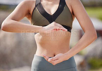 Buy stock photo Shot of an unrecognizable woman making a gesture over her stomach after her workout in the park