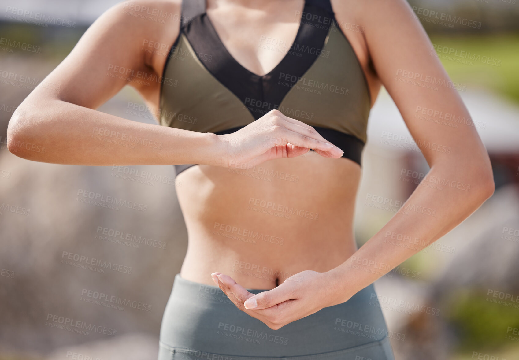 Buy stock photo Shot of an unrecognizable woman making a gesture over her stomach after her workout in the park