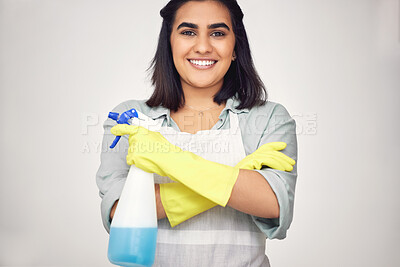 Buy stock photo Shot of a confident young woman standing with her arms crossed while cleaning at home