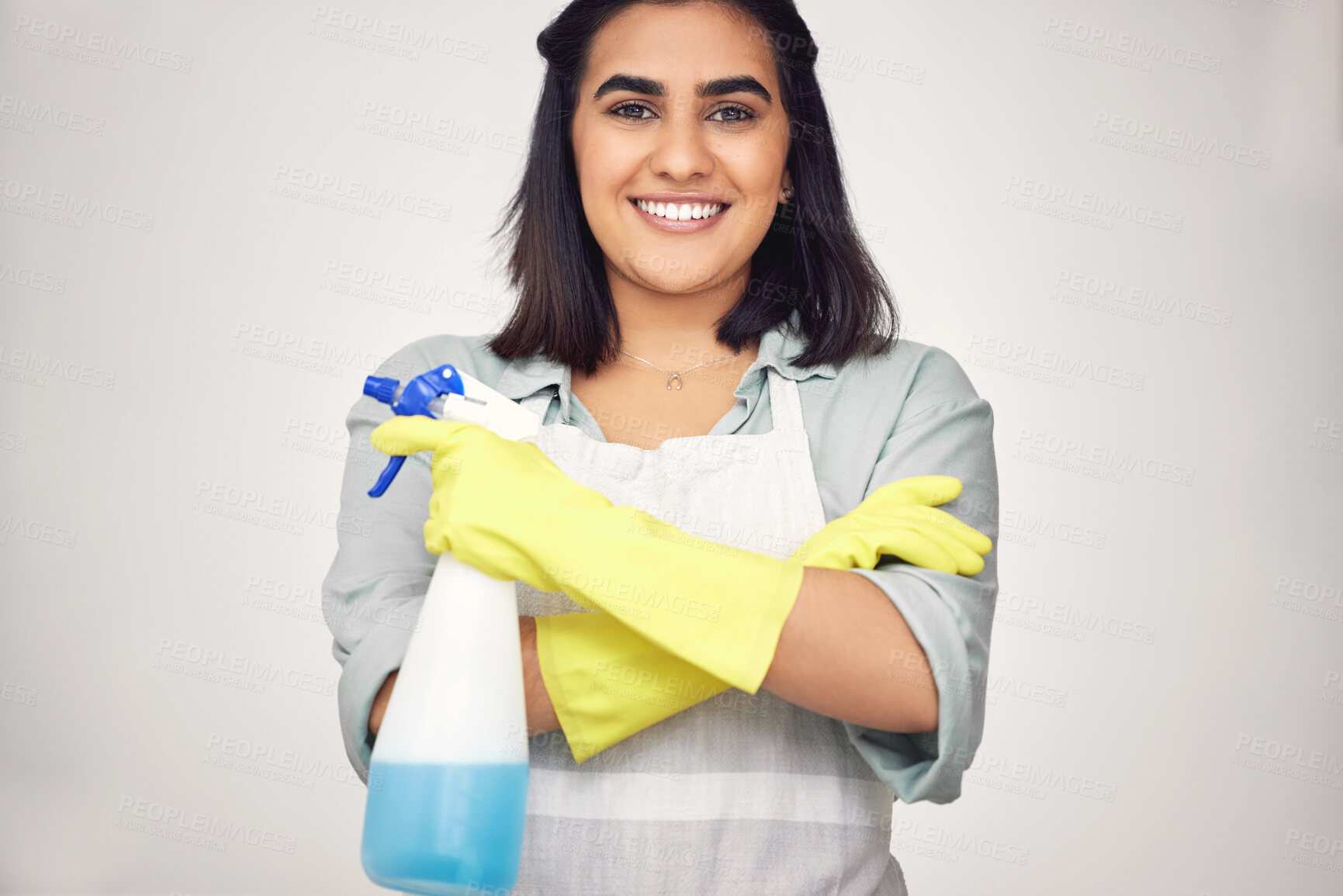 Buy stock photo Woman, portrait and smile with gloves or confidence in house for cleaning, scrub and dirt on window. Housekeeper, happy and apron with detergent in bottle for dust in home on white background