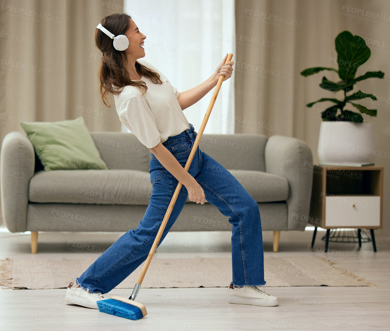 Buy stock photo Woman, singer and broom to clean living room with funny dance, sweeping floor and rock performance in home. Girl, comic singing and cleaner with spring cleaning, music and headphones for guitar solo