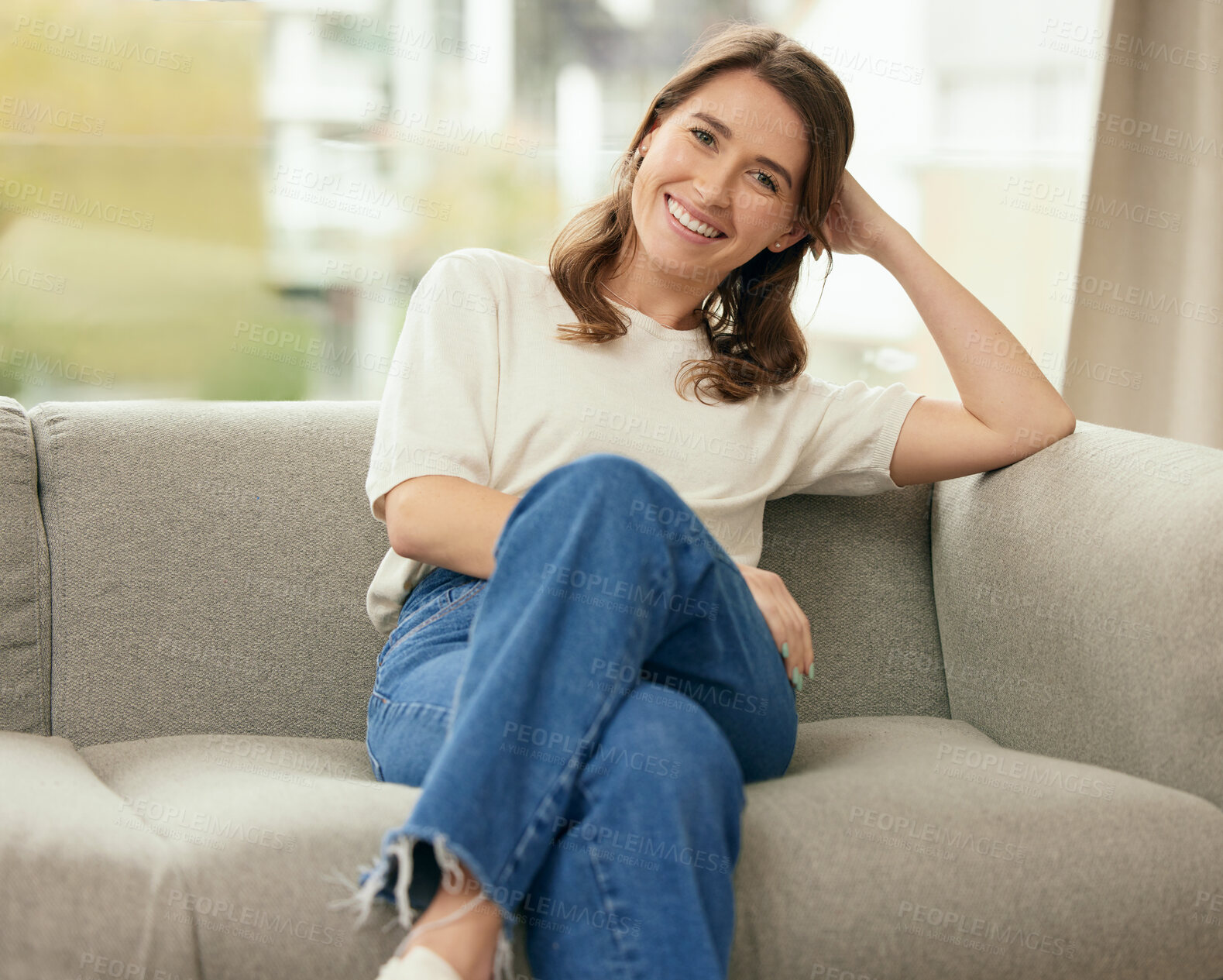 Buy stock photo Portrait, smile and woman on couch in home living room for relax, calm and peace in apartment in Germany. Jeans, confidence and happy girl on sofa for comfort in lounge in casual clothes in house