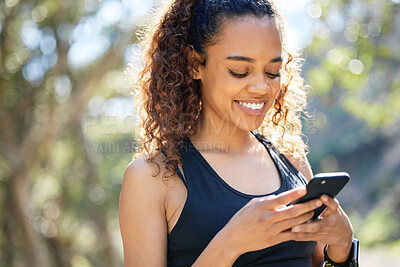 Buy stock photo Shot of a young businesswoman using her smartphone before a run