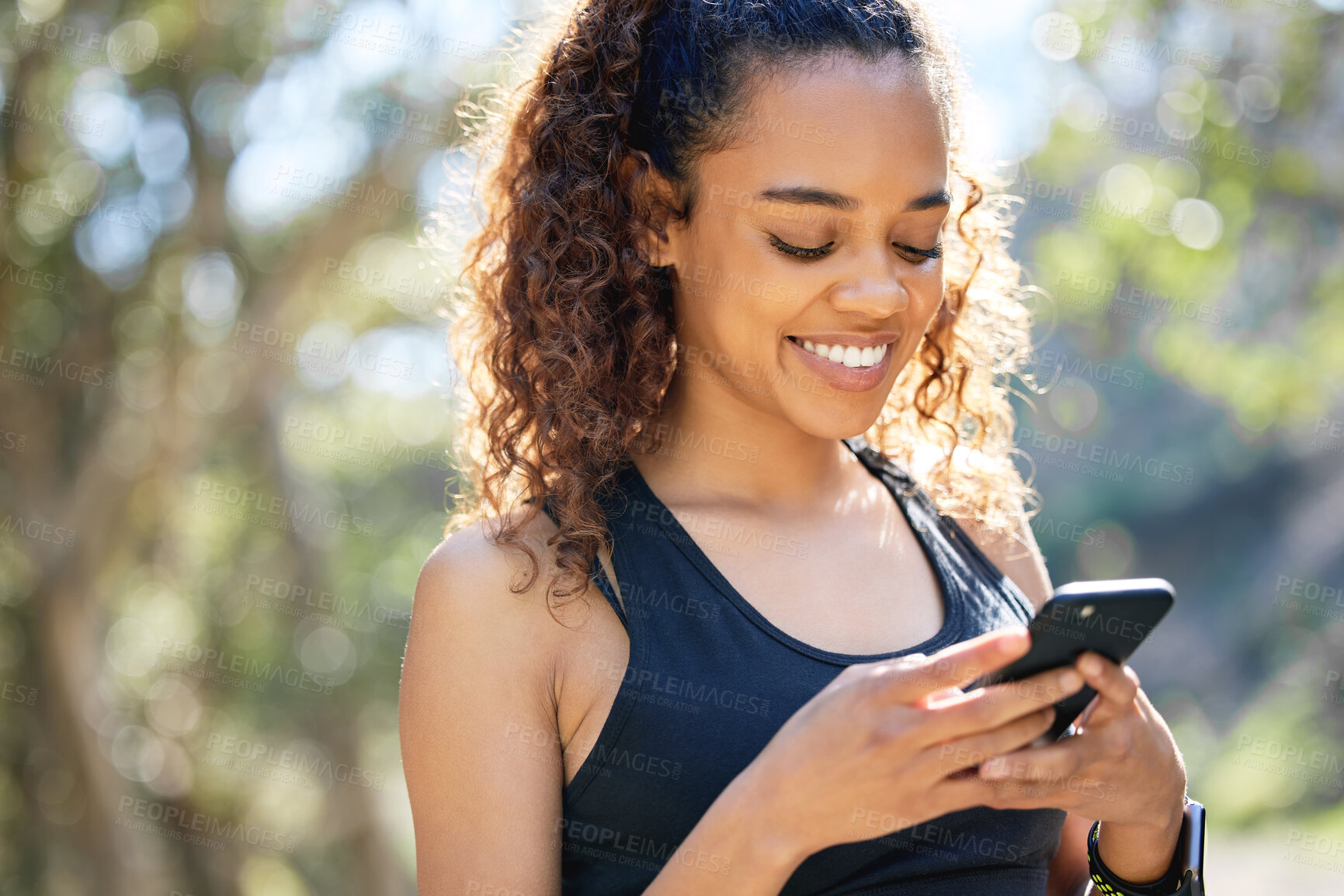 Buy stock photo Shot of a young businesswoman using her smartphone before a run