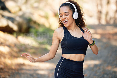 Buy stock photo Shot of a young woman dancing to fun music during a run