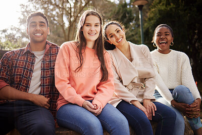 Buy stock photo Portrait of four young university students sitting outside on campus during their break