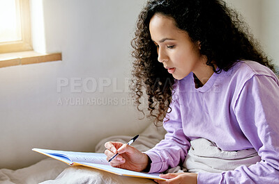 Buy stock photo Shot of a young female studying while sitting in bed