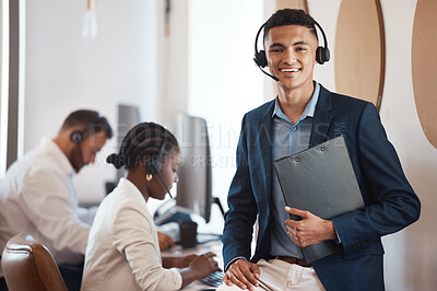 Buy stock photo Portrait of a young call centre agent holding a folder in an office with his colleagues in the background