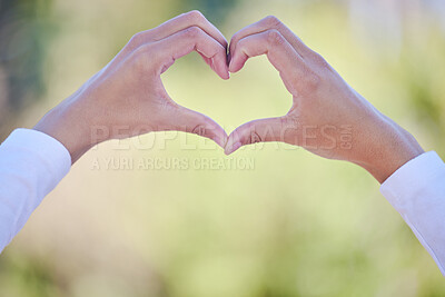 Buy stock photo Outdoor, hands and heart with woman, support and kindness with icon, symbol for love and care. Closeup, person and girl in park, gesture or peace with emoji, promotion and summer with nature or light