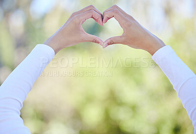 Buy stock photo Outdoor, hands and heart with woman, care and kindness with icon, symbol for love and promotion. Closeup, person and girl in park, gesture and peace with emoji, support and summer with gratitude