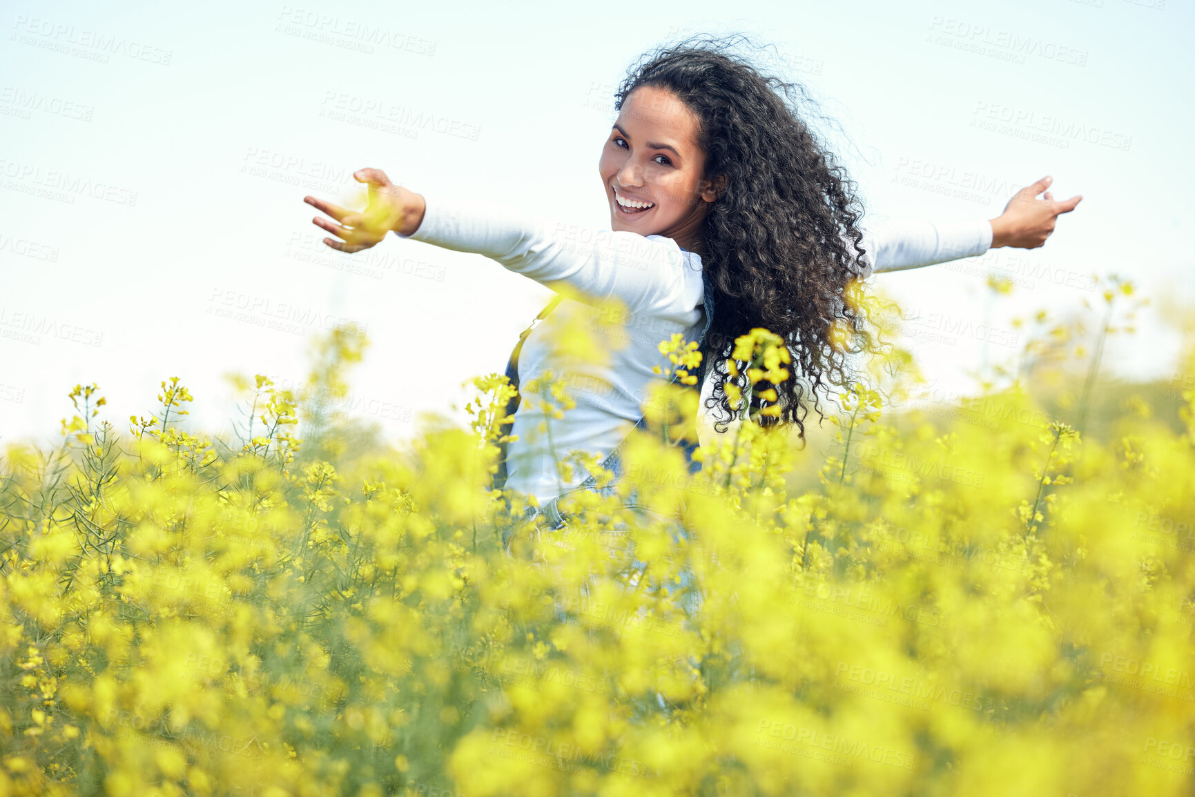 Buy stock photo Portrait, happy and woman in field of flowers for adventure, travel and nature in countryside. Gen z, female person and environment for sustainability, ecology and sunshine in grass with smile