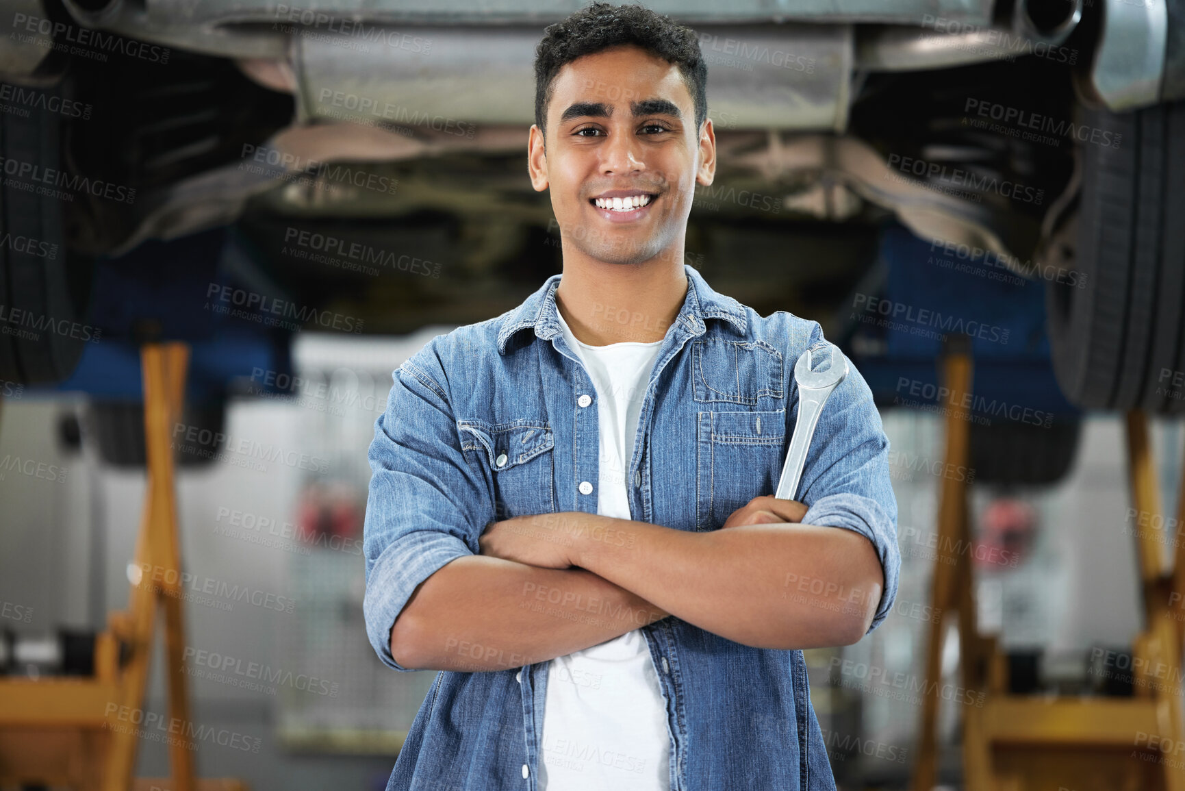 Buy stock photo Portrait, man and smile as mechanic in automobile, workshop and repairs with confident or pride as engineer. Male person, spanner and automotive in industry as maintenance, service or expert for cars