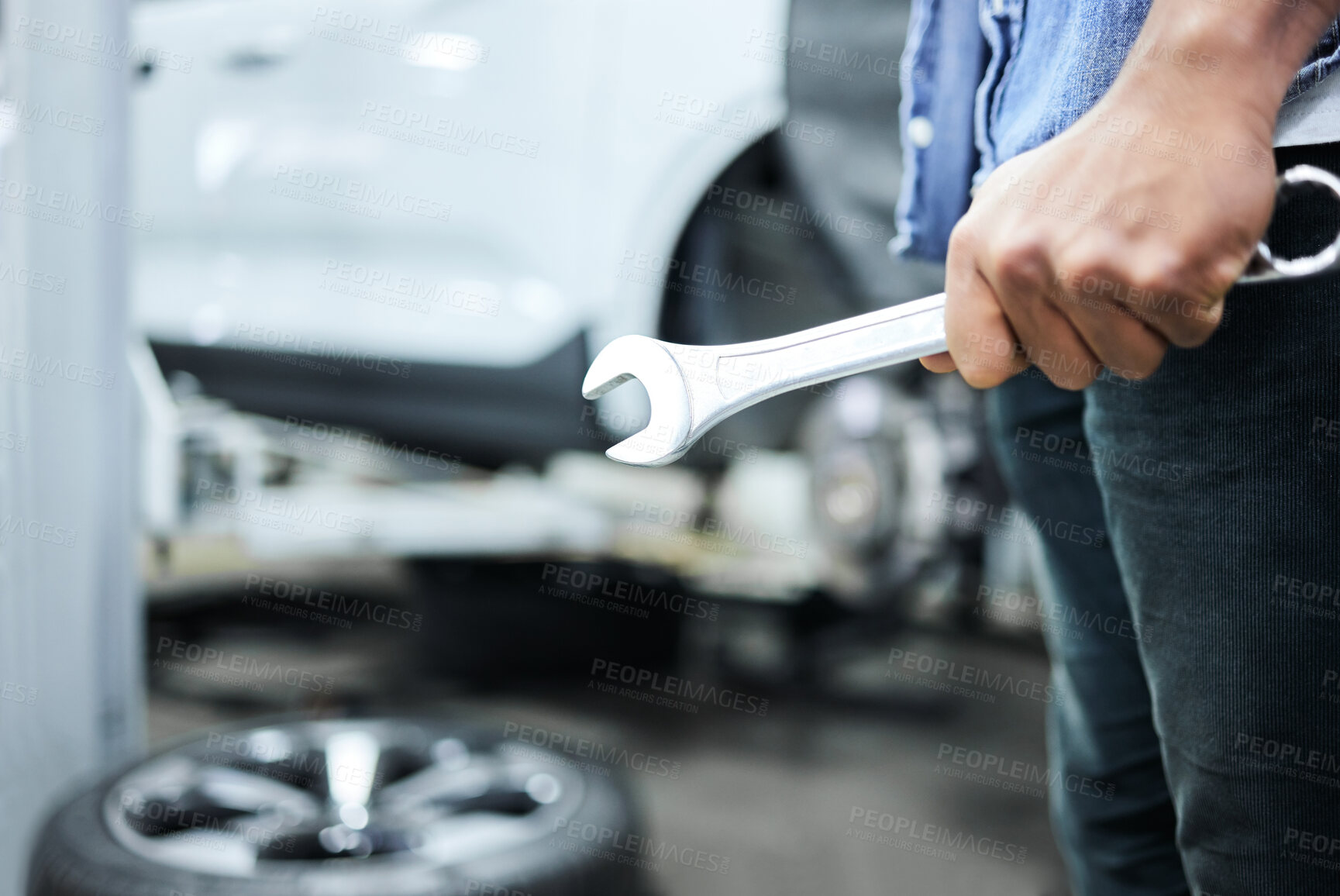 Buy stock photo Mechanic, person and hand with wrench in workshop for maintenance, tire change and motor repair. Garage, inspection and automobile industry with tools for car service, alignment or vehicle assistance
