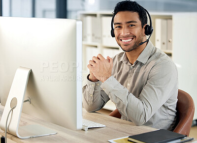 Buy stock photo Portrait of a young businessman using a headset and computer in a modern office