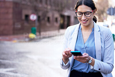 Buy stock photo Shot of a young businesswoman using her smartphone to send a text message