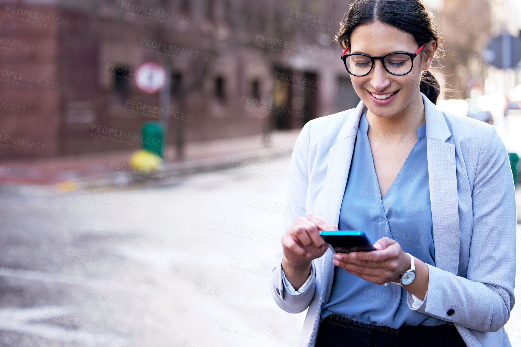 Buy stock photo Shot of a young businesswoman using her smartphone to send a text message